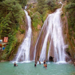 Panoramic view of Mussoorie Kempty Fall surrounded by lush green hills in Mussoorie.